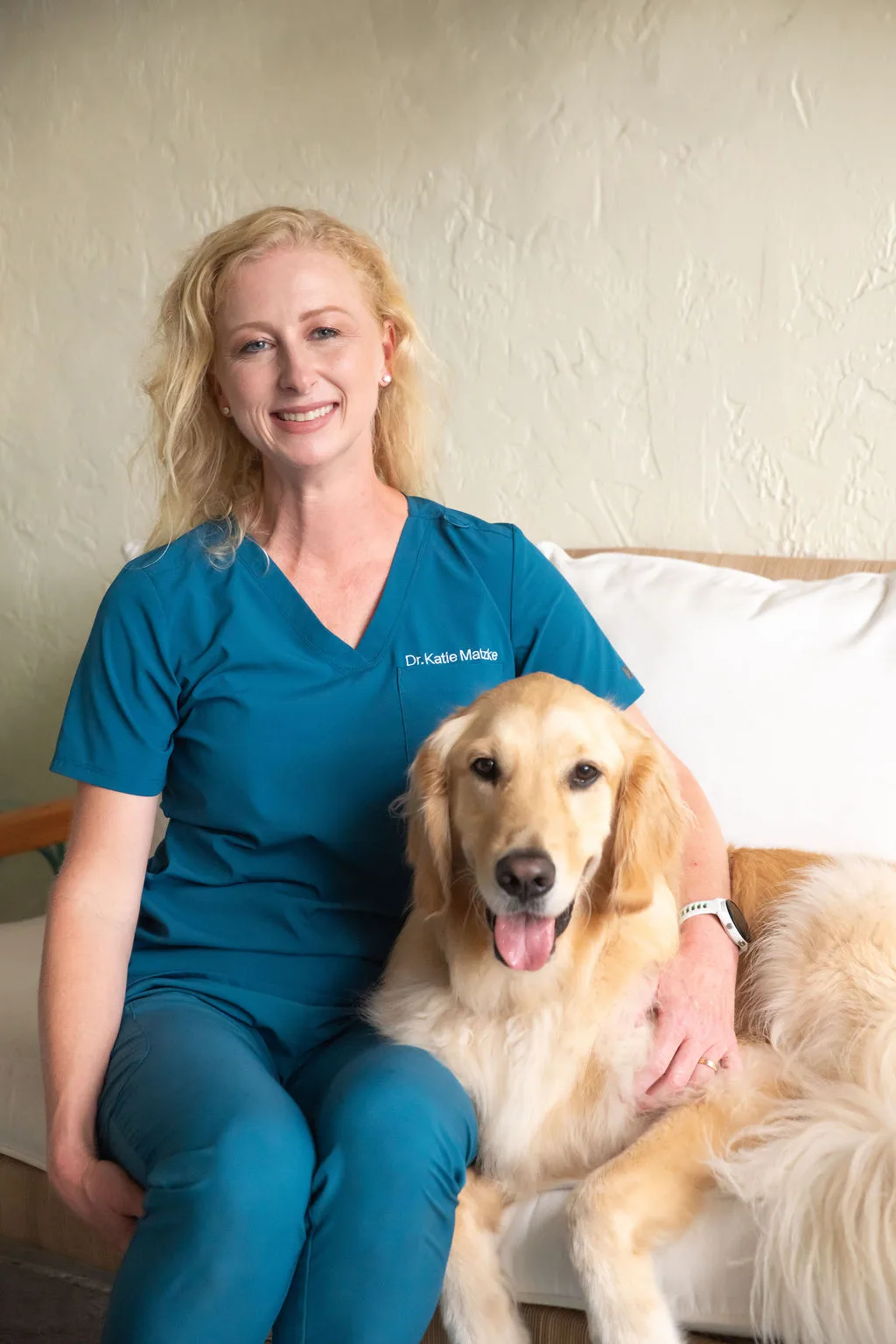 Dr. Katie sitting with a dog during an in-home visit