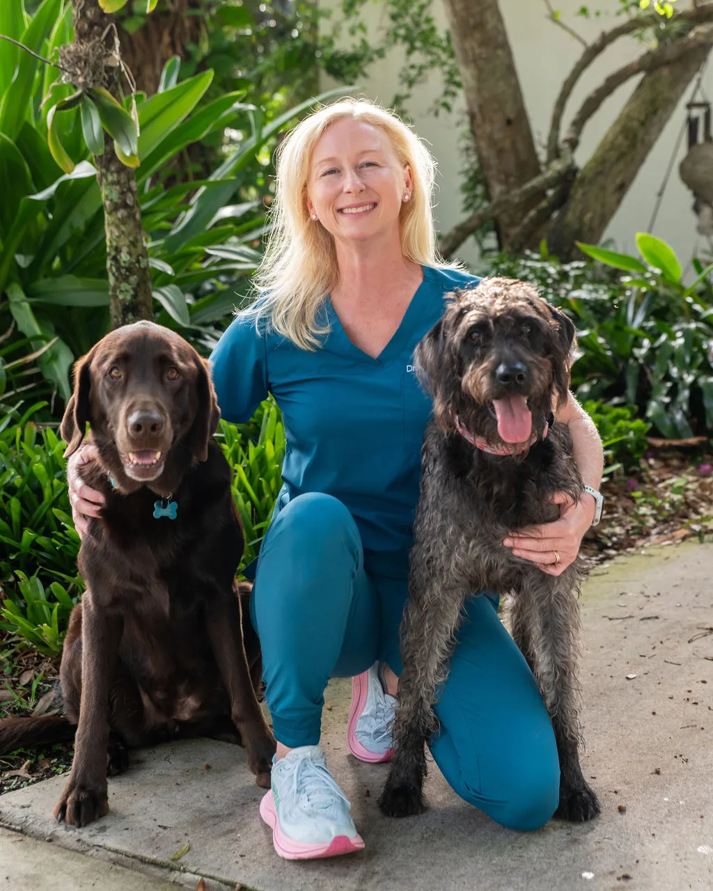 Dr. Katie with two dogs during a home visit